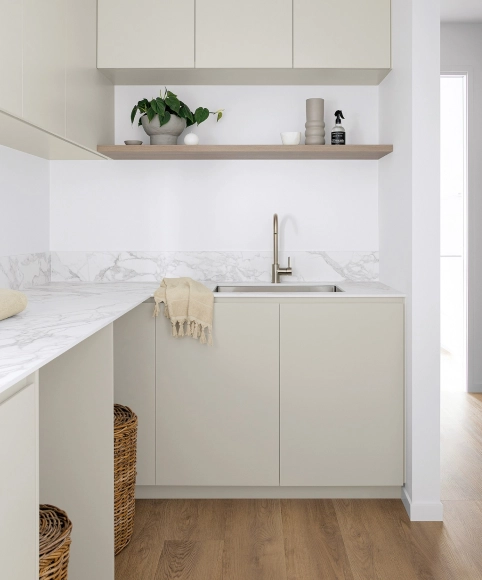 Laundry room featuring white cabinets with chrome pulls and a butcher block countertop.