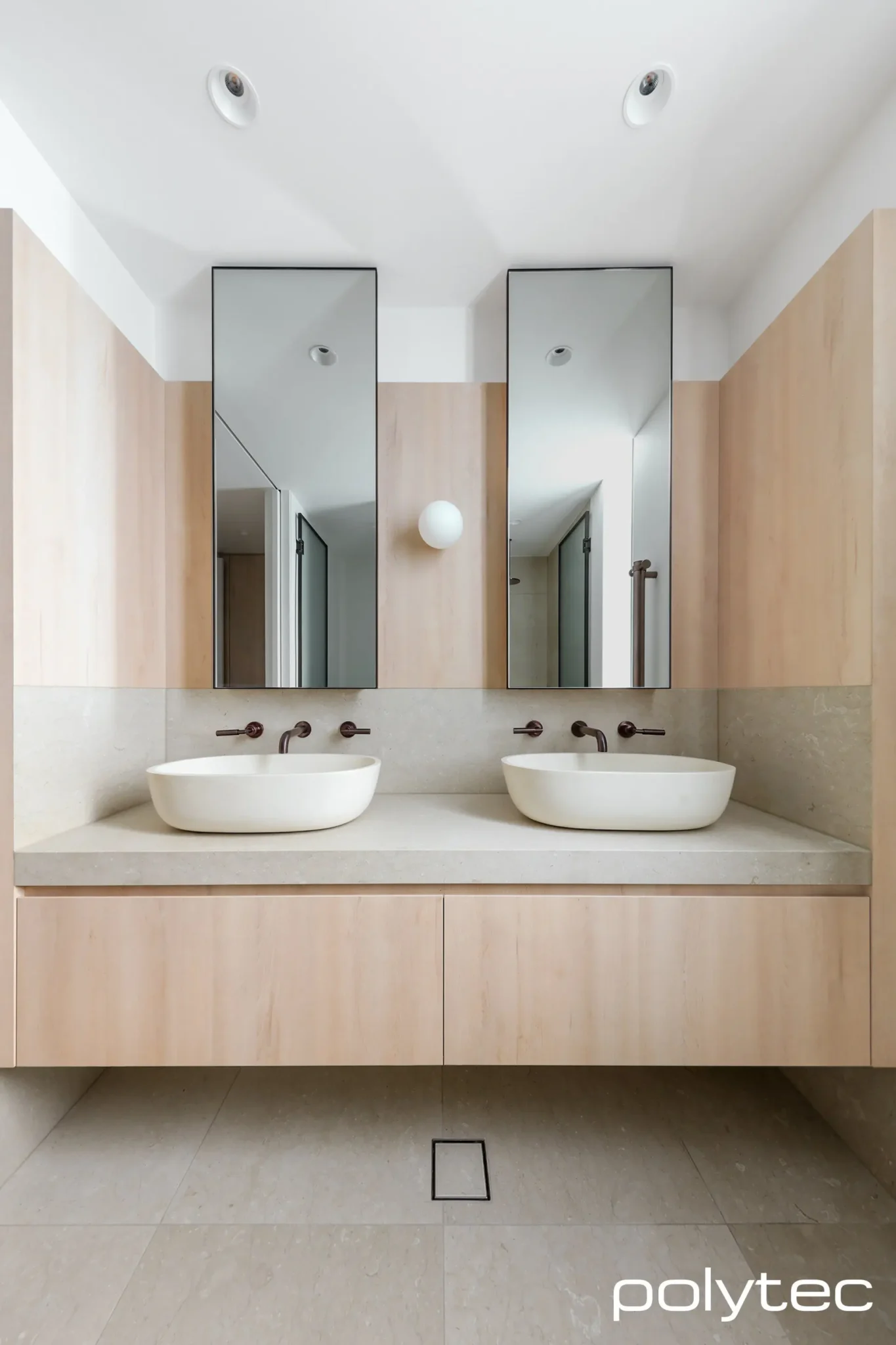 Modern bathroom with two rectangular sinks with chrome faucets mounted on a countertop.